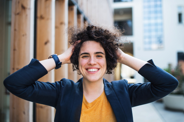 A happy young business woman standing outdoors, resting. Start-up concept.