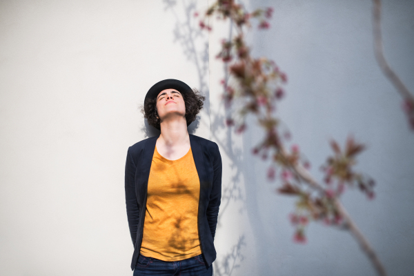 A young businesswoman with closed eyes standing outdoors, relaxing. Copy space. Start-up concept.