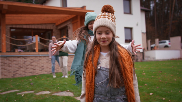 Two happy sisters playing and hugging outdoors in a garden in autumn