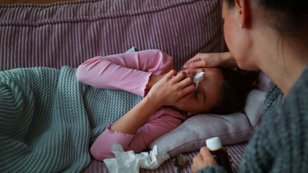 A mother taking care of her sick daughter at home.