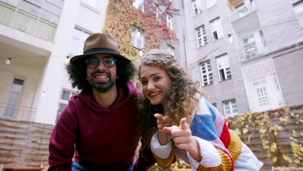 Young couple with guitar making video for social media outdoors on street.