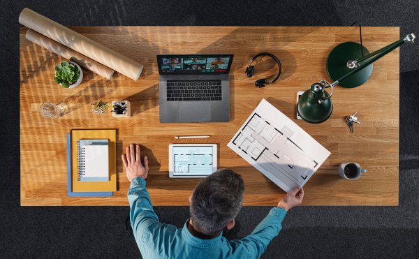 A top view of architect working on computer at desk in home office, video call concept.