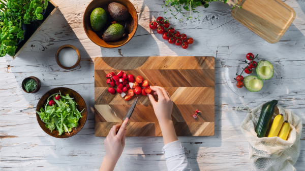 A top view of unrecognizable woman preparing vegetable salad, sustainable lifestyle.