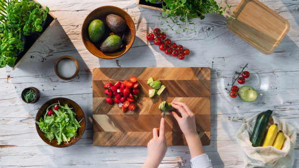 A top view of unrecognizable woman preparing vegetable salad, sustainable lifestyle.