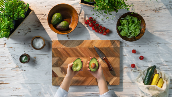 A top view of unrecognizable woman preparing vegetable salad, sustainable lifestyle.