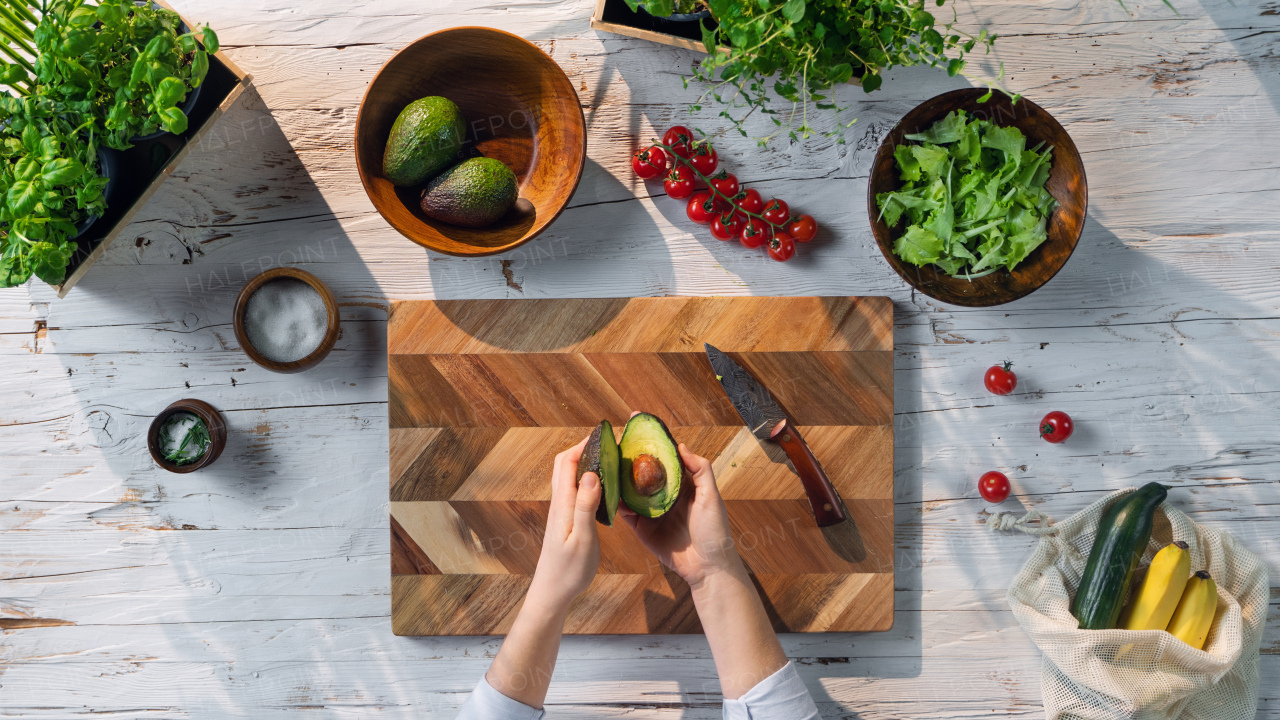 A top view of unrecognizable woman preparing vegetable salad, sustainable lifestyle.