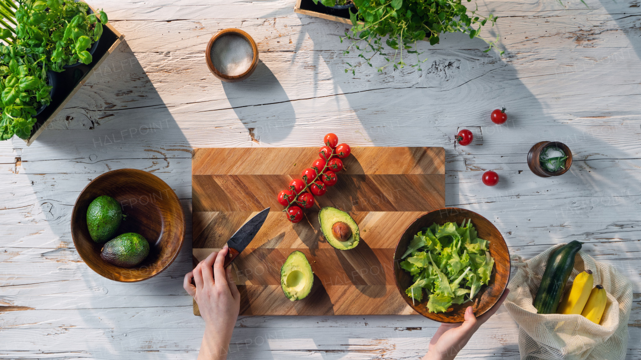 A top view of unrecognizable woman preparing vegetable salad, sustainable lifestyle.