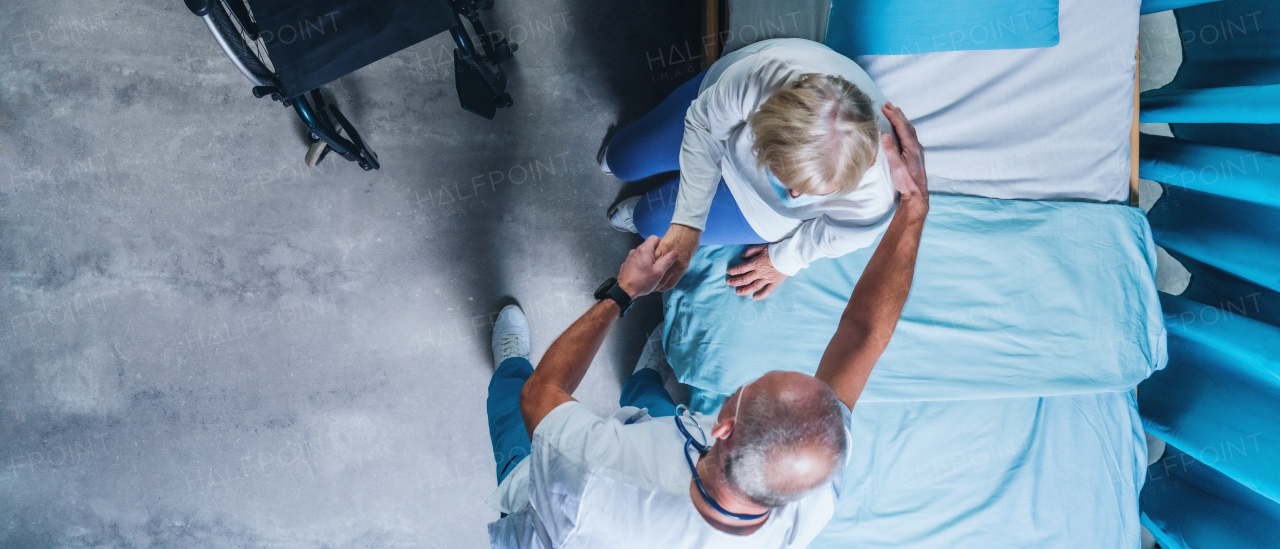 Top view of doctor talking to covid-19 patient in bed in hospital, coronavirus concept.