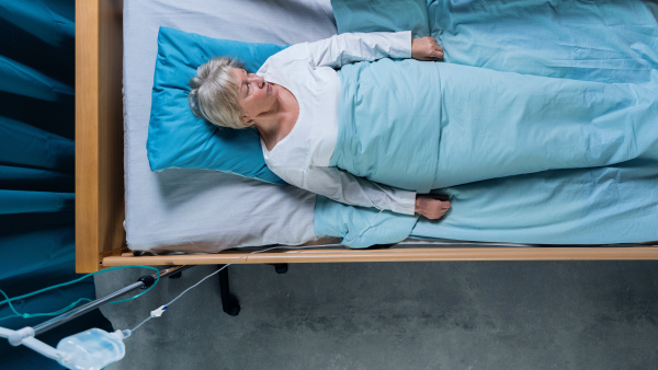 Top view of woman patient with iv saline drip in bed in hospital. Copy space.