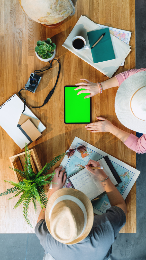 Top view of young couple with tablet planning vacation trip holiday, desktop travel and green screen.