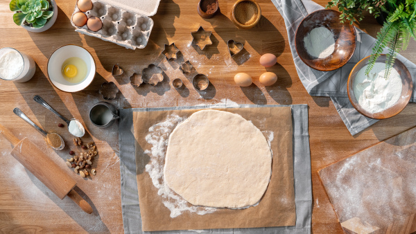 A flat lay top view of dough and baking ingredients, desktop concept.