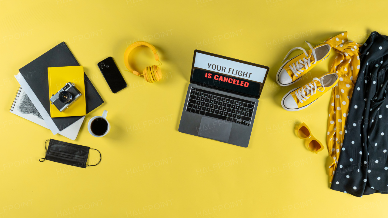 Top view of travel essentials on desk on yellow background , coronavirus desktop concept.