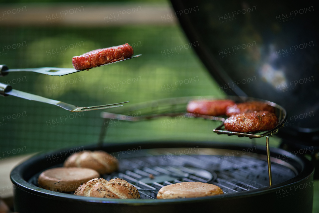 A close up of barbecue grill with burgers on it.