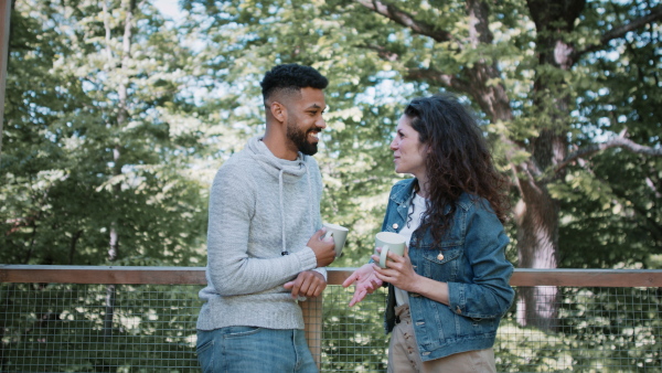 A happy couple resting and talking outdoors in a tree house, weekend away and digital detox concept.