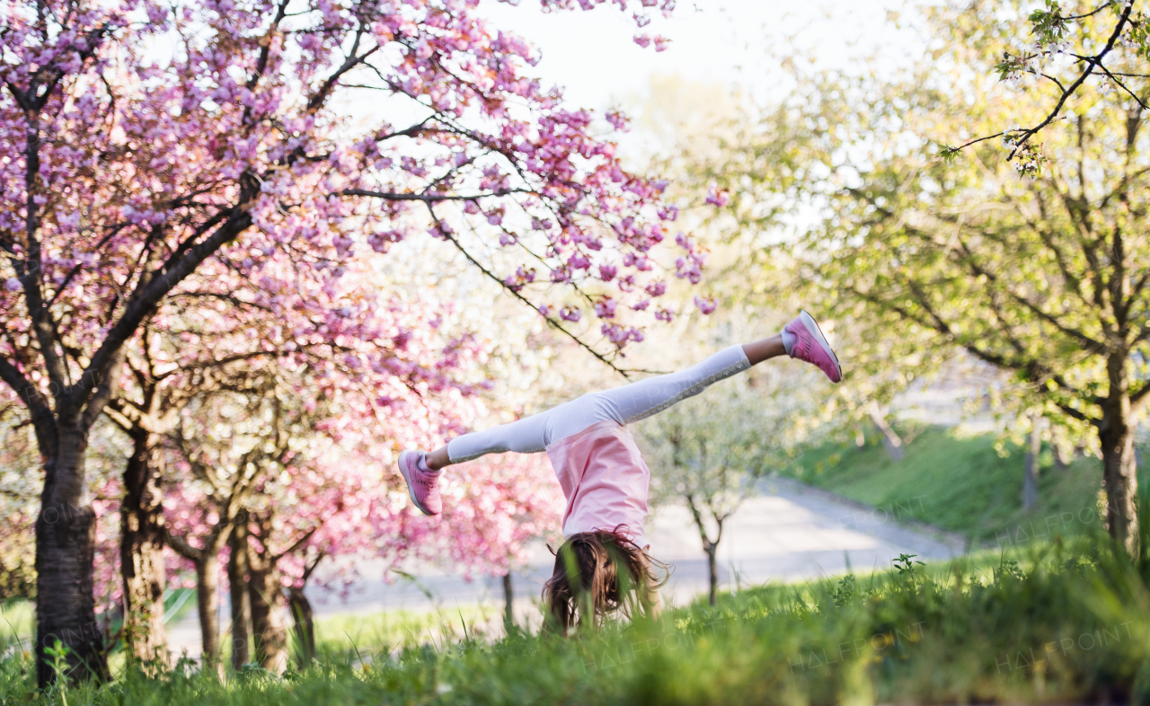 A cheerful small girl playing outside in spring nature.