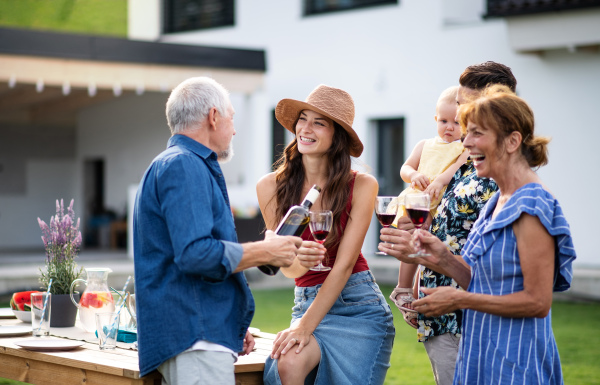 Portrait of people with wine outdoors on family garden barbecue, drinking wine.