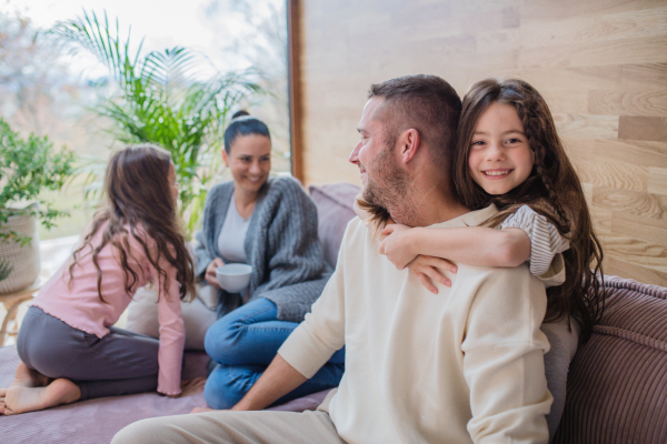 Two happy sisters having fun with a father at home