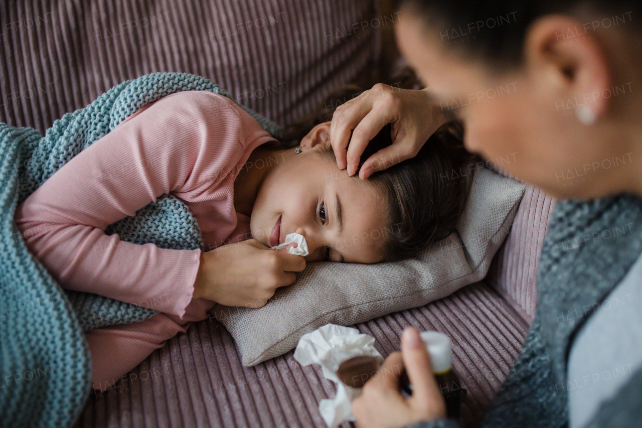 A mother taking care of her sick daughter at home.