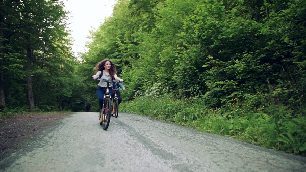 Young tourist couple travellers with backpacks riding electric scooters in nature. Slow motion.