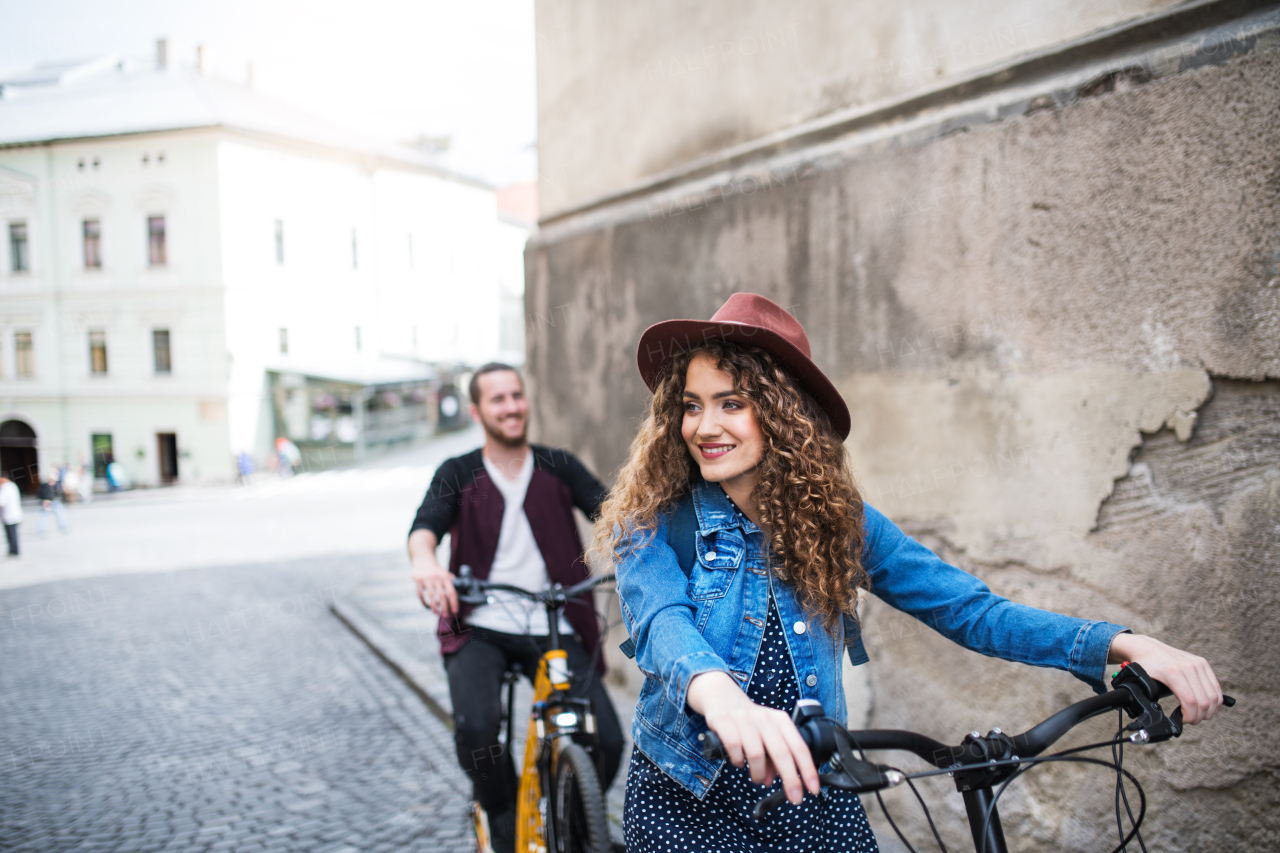 Young tourist couple travellers with electric scooters in small town, sightseeing.