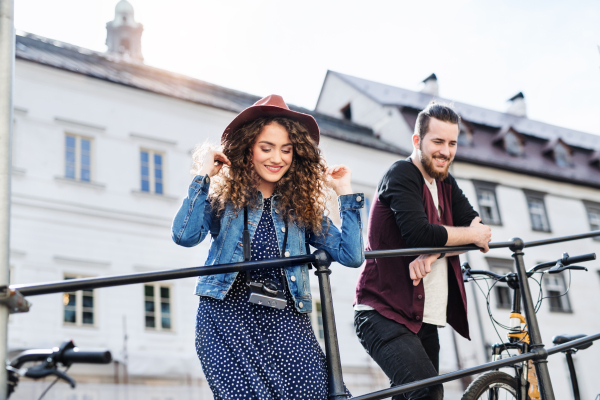 Young tourist couple travellers with scooters in small town, sightseeing.