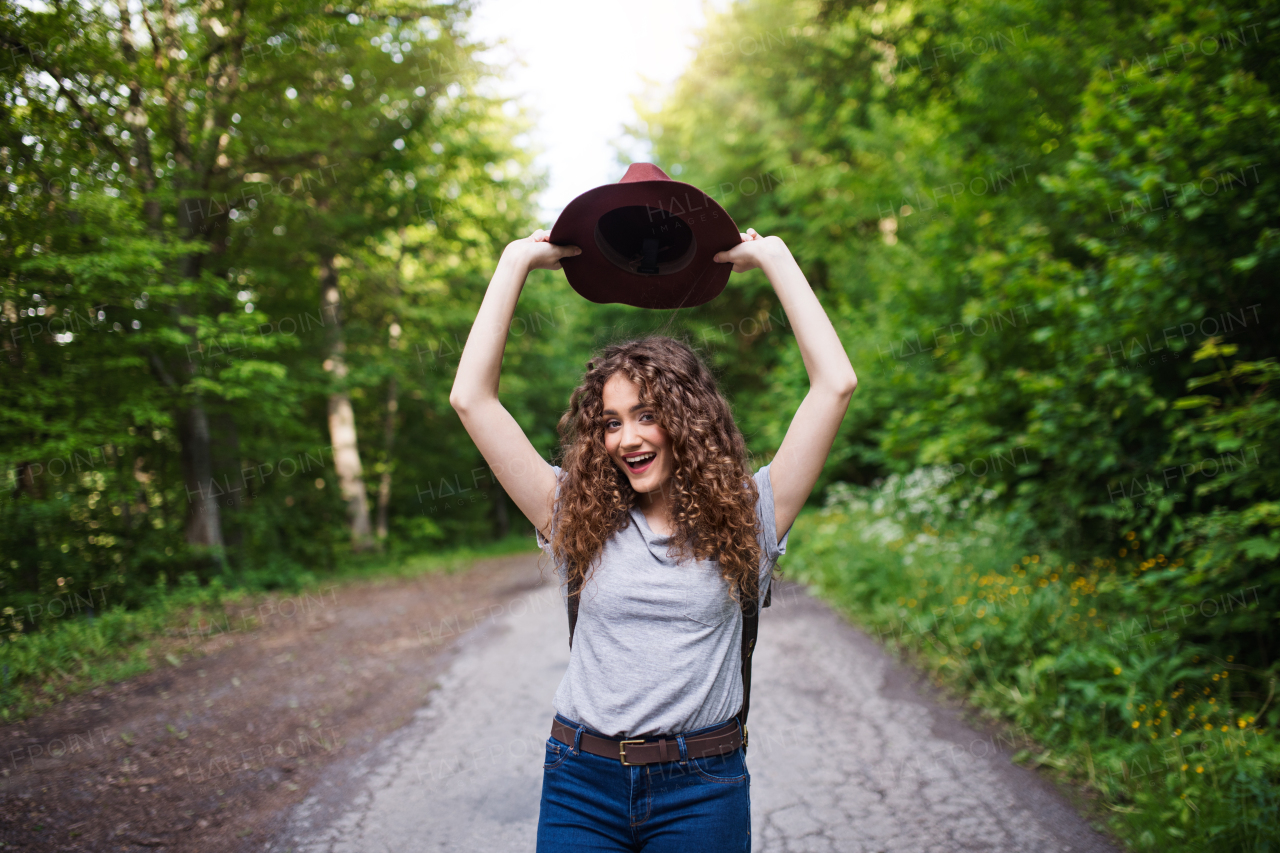 Young happy tourist woman traveller with backpack walking in nature.