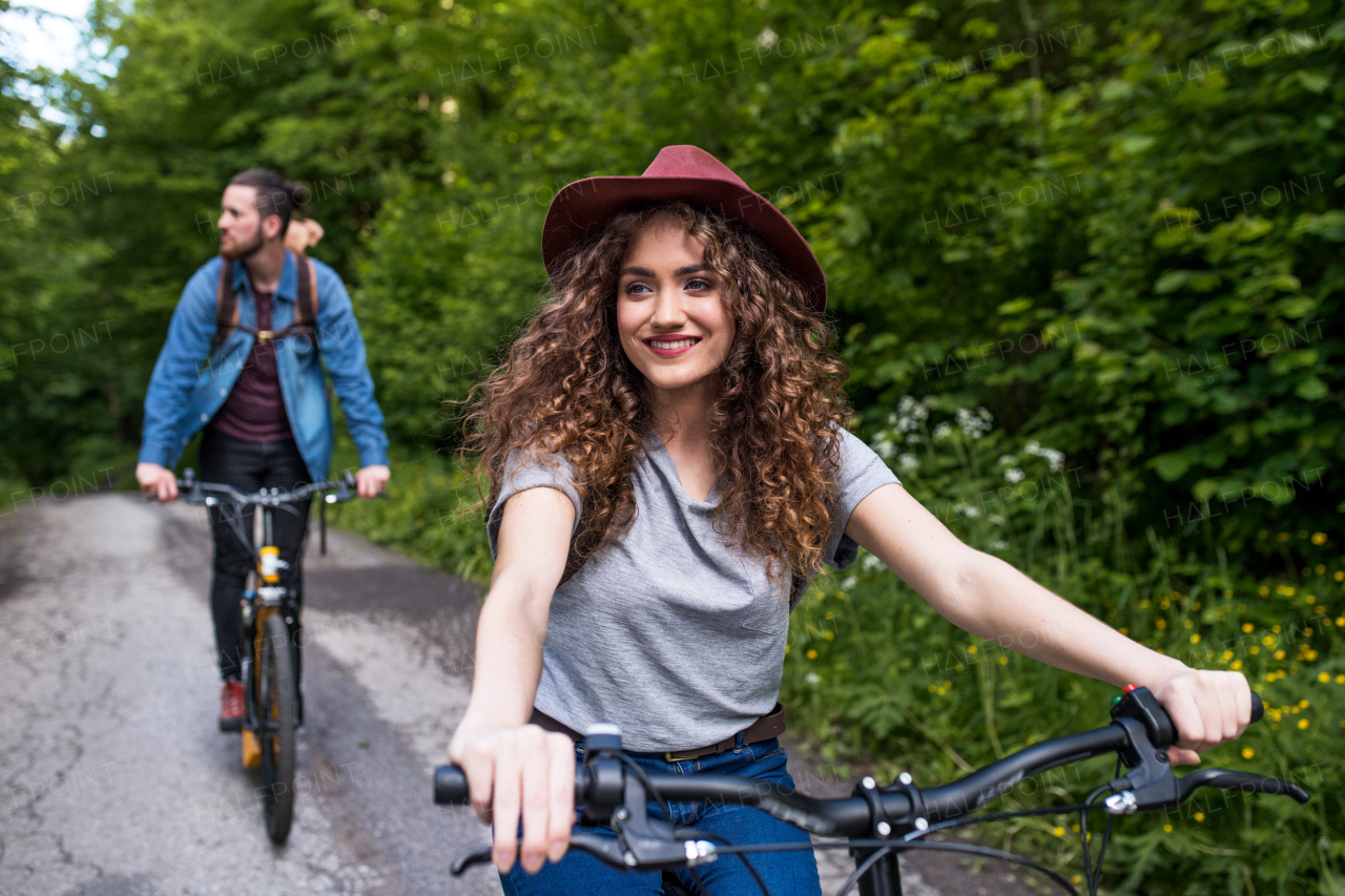 Young tourist couple travellers with backpacks and electric scooters in nature.