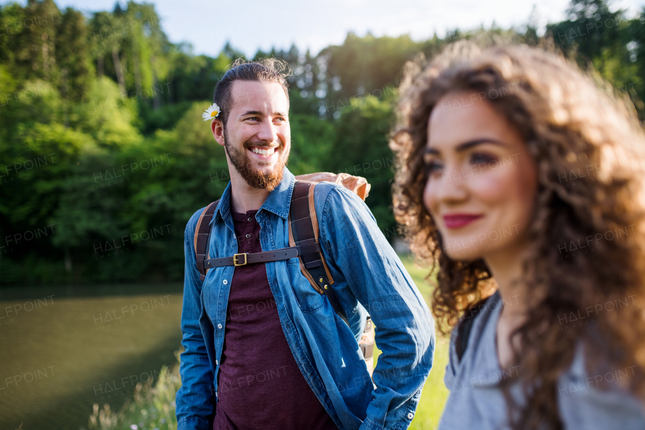 Young tourist couple travellers on a walk by lake in nature, walking.