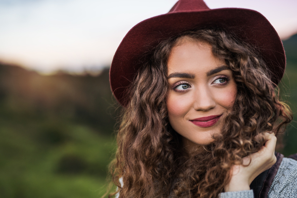 Close-up portrait of young woman traveller standing in nature. Copy space.