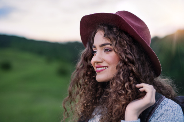 Close-up portrait of young woman traveller standing in nature. Copy space.