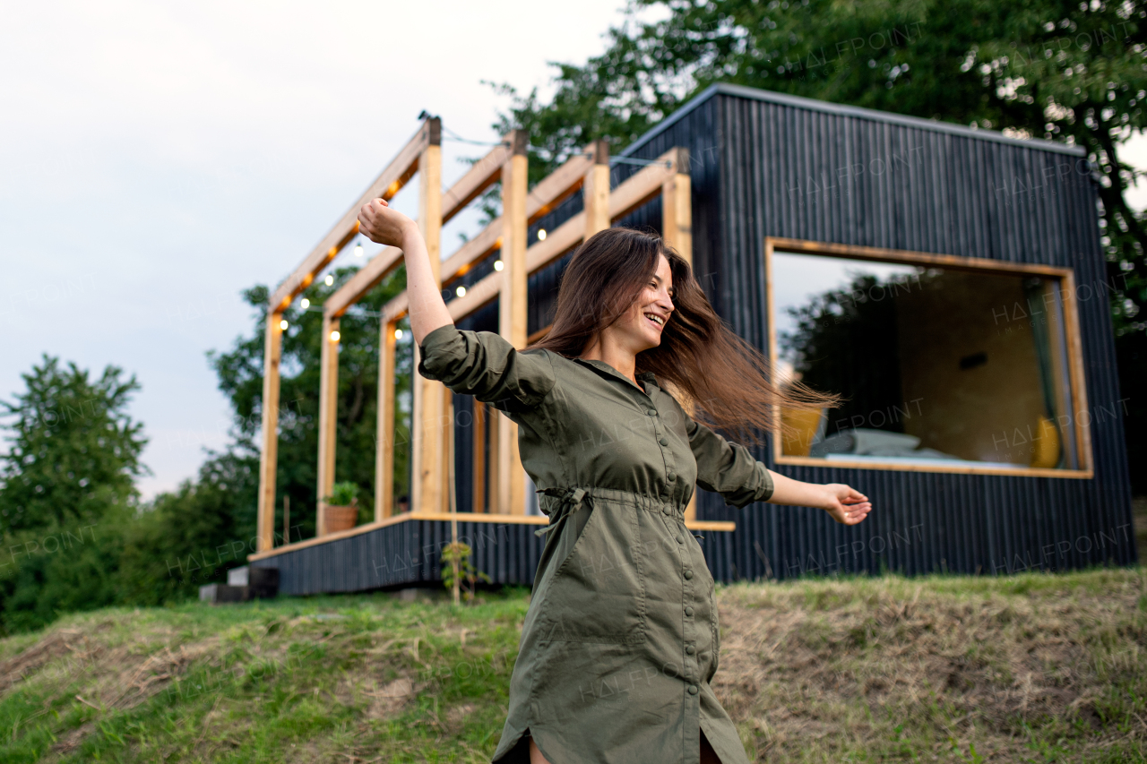 Young woman running outdoors, weekend away in container house in countryside.