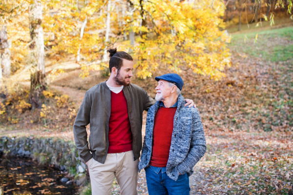 Senior father and his young son walking in nature, talking.