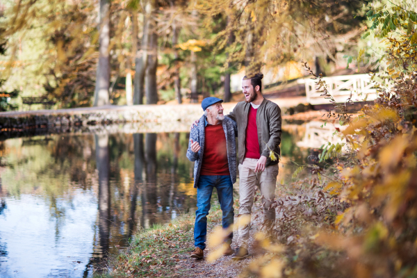 Senior father and his young son walking in nature, talking.