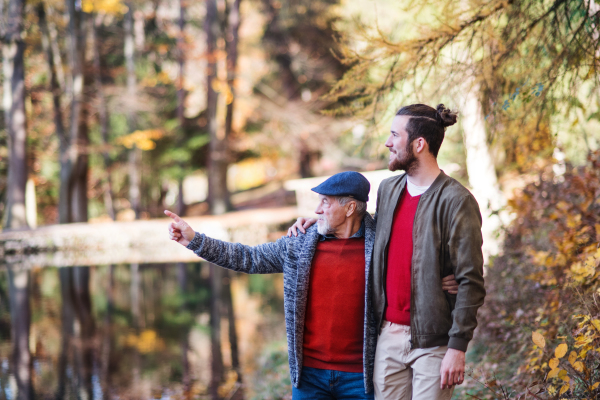 Senior father and his young son walking in nature, talking.