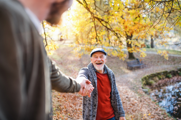 Senior father and his young son walking in nature, talking.