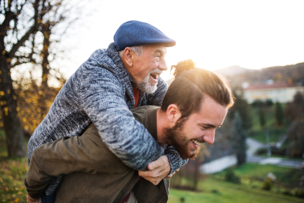 Senior father and his young son walking in nature, having fun.