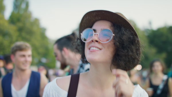 Beautiful young woman with friends dancing at summer festival.