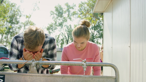 A group of young friends at summer festival, washing in the morning.