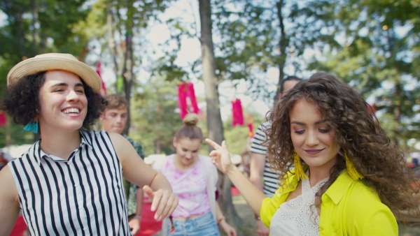 A group of young friends at summer festival, having good time, dancing.