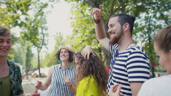 Group of cheerful young friends at summer festival, having good time.