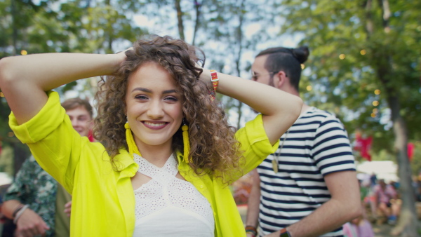 A group of young friends at summer festival, having good time, dancing.