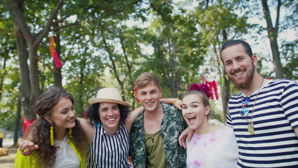 Group of cheerful young friends at summer festival, having good time.