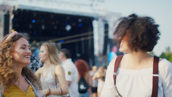 Group of cheerful young friends at summer festival, having good time.