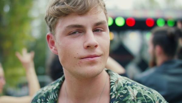 A young man at summer festival, having fun, dancing and singing.