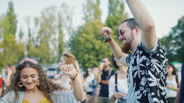 Group of cheerful young friends at summer festival, having good time.