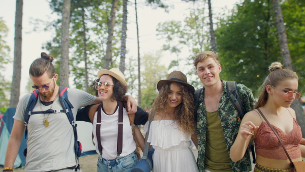 A group of cheerful young friends dancing at summer festival.