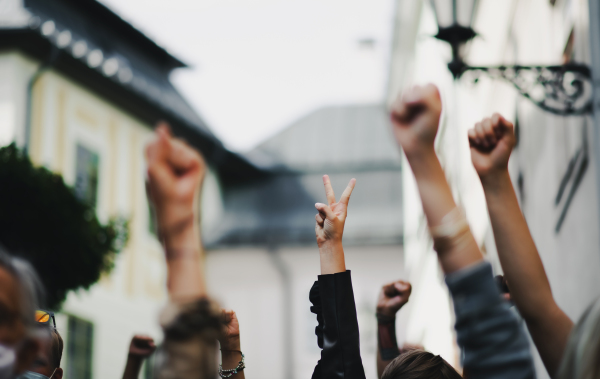 Arms and fists of unrecognizable people raised in the air, protest and demonstration concept.