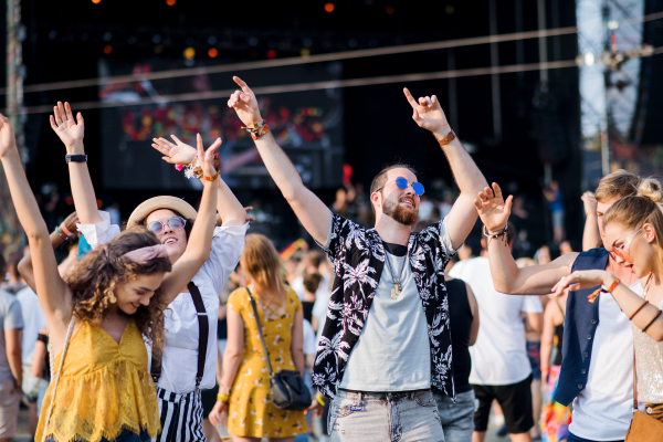 A front view portrait of group of young friends dancing at summer festival.