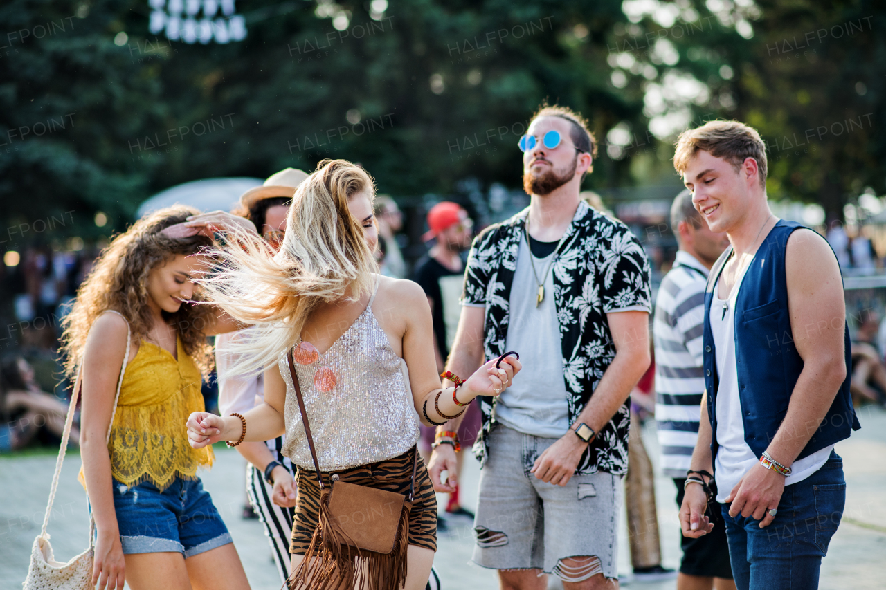 A front view portrait of group of young friends dancing at summer festival.