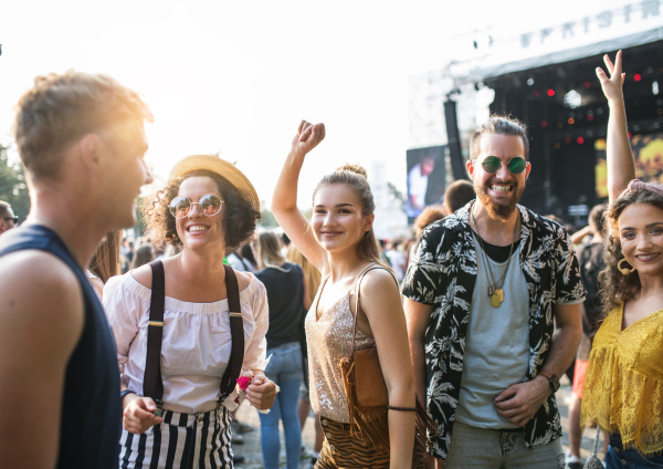 A front view portrait of group of young friends dancing at summer festival.